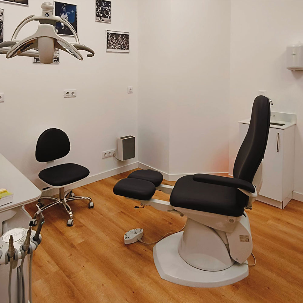 Consulta médica privada en clínica sanitaria con escritorio, sillas para paciente, iluminación cálida y ambiente tranquilo.