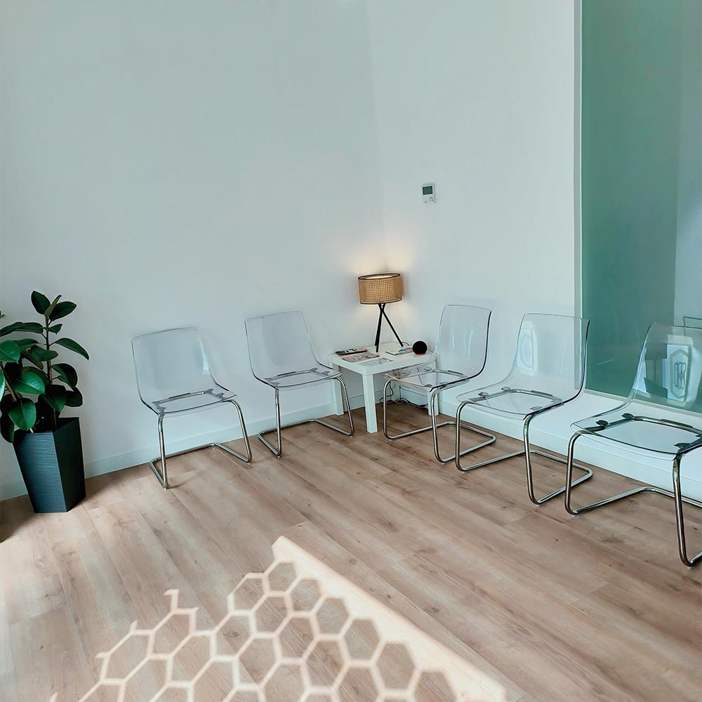 Sala de espera de Clínica Ribadavia con sillas modernas, mesa auxiliar y ambiente luminoso y tranquilo